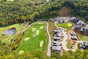 A golf course with a clubhouse, residential buildings, and a parking area. - Balsam Preserve Private Resort | Golf, Spa, Hiking (Sylva)