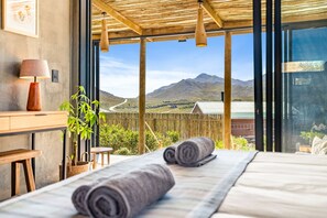 A bedroom with a large window, a wooden ceiling, and a view of mountains. - KOH Pringle Pod - One Bedroom House, Sleeps 2 (Pringle Bay)