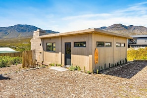 A single-story building with a flat roof, a small porch, and a wooden fence. - KOH Pringle Pod - One Bedroom House, Sleeps 2 (Pringle Bay)