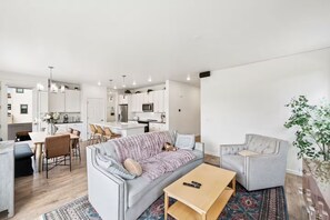 A modern living room with a grey sofa, a coffee table, and a TV. - Sundance 2027 Retreat //4BR + Gym + 2-Car Garage (Superior)