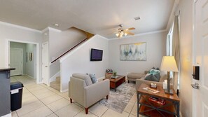 A modern living room with a sofa, coffee table, and a television mounted on the wall. - University Place - 3.5 miles to Kyle Field, Pool access! (College Station)