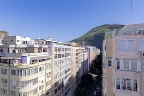 A multi-story building with balconies and a narrow street between it and another building. - South Beach - Copacabana (Rio de Janeiro)