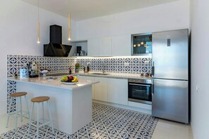 A modern kitchen with a central island, bar stools, a built-in oven, and a stainless steel refrigerator. - Villa with views over the Amalfi Coast and jacuzzi (Furore)