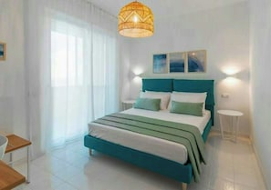 A bedroom with a bed, bedside tables, a hanging light fixture, and a window with curtains. - Villa with views over the Amalfi Coast and jacuzzi (Furore)