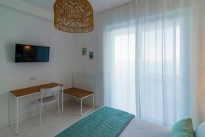 A room with a bed, a desk, a chair, a television, and a window with sheer curtains. - Villa with views over the Amalfi Coast and jacuzzi (Furore)