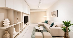 A modern living room with a sofa, coffee table, and shelving unit. - Victoria Levanco Apt by TrulyCyprus (Lemesos)