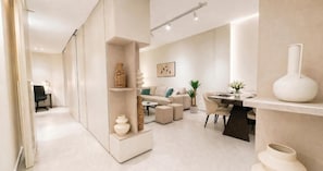 A modern living room with a sofa, coffee table, and decorative items. - Victoria Levanco Apt by TrulyCyprus (Lemesos)