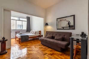 A room with a bed, a sofa, a table, and a lamp. - Cozy Apartment in Botafogo With A C and Wi-fi - Sct604 (Rio de Janeiro)