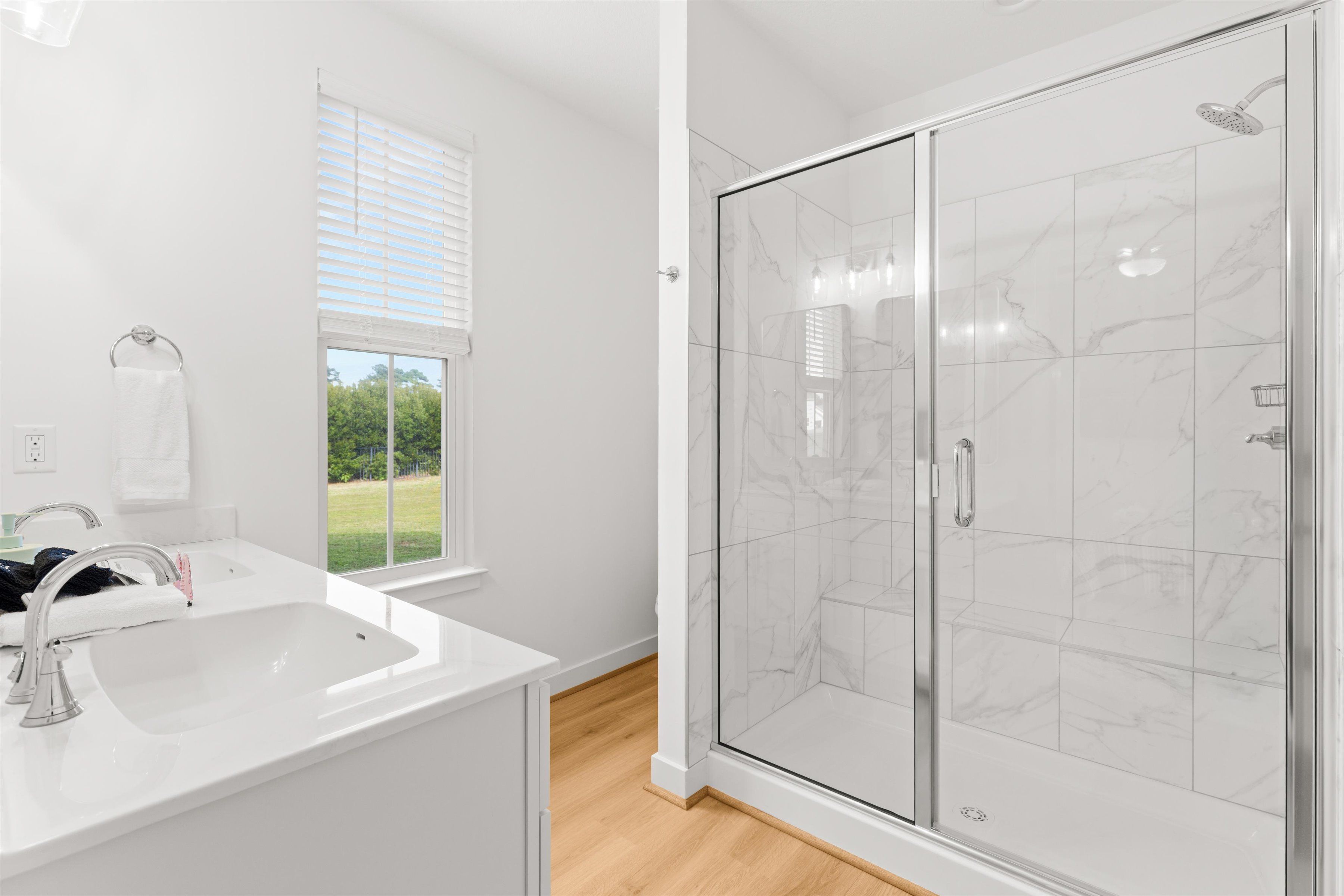 Bright spa-style bath with large walk-in glass shower and natural light