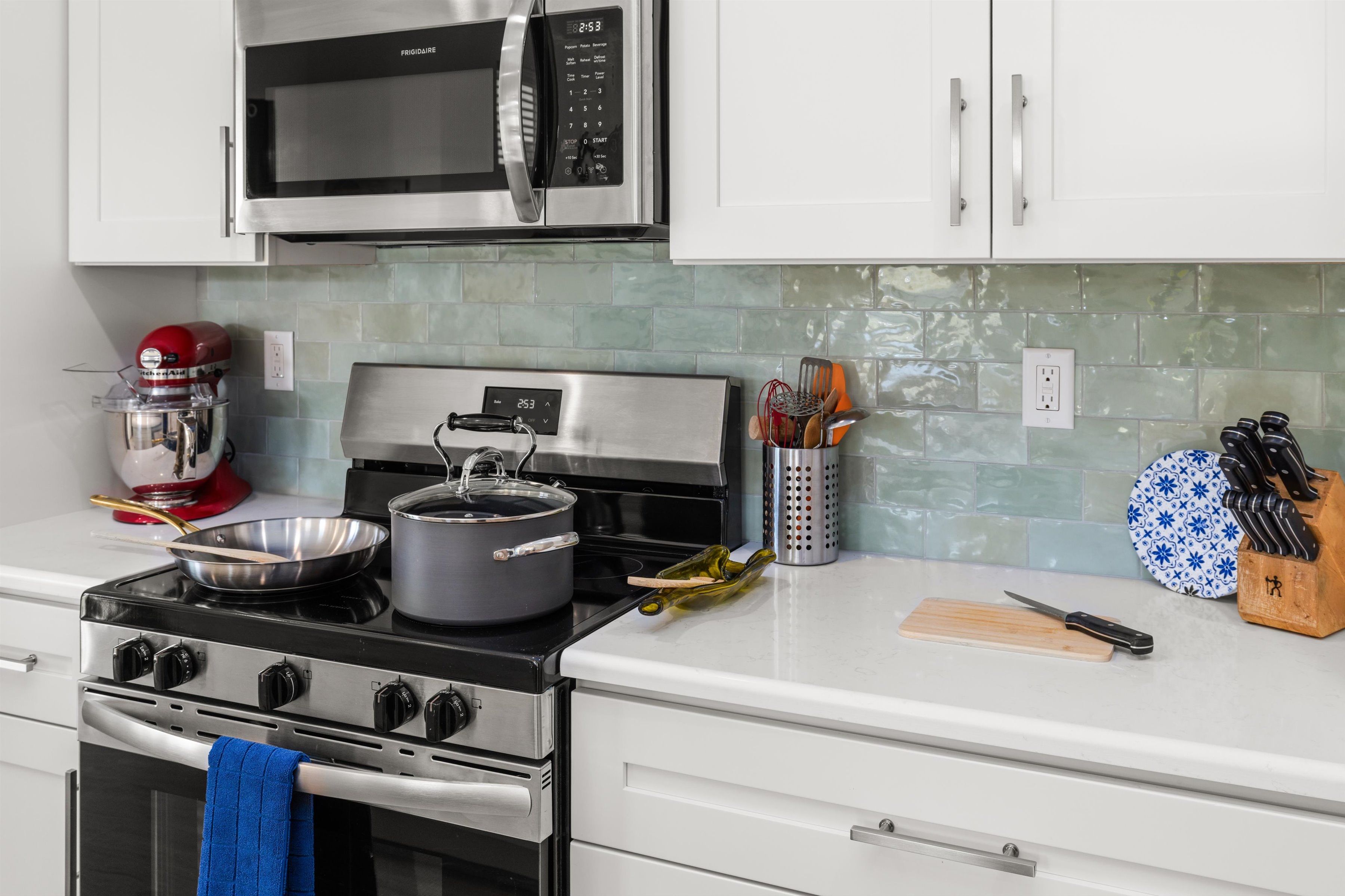 Bright modern kitchen with stainless appliances and stylish tile backsplash