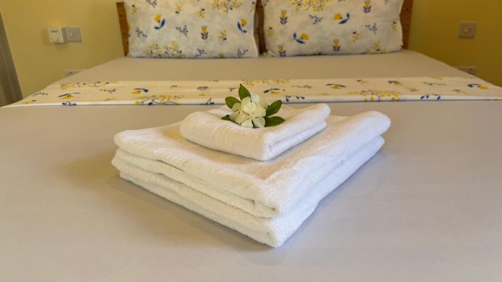 A neatly made bed with a floral-patterned bedspread and two pillows with a similar design.