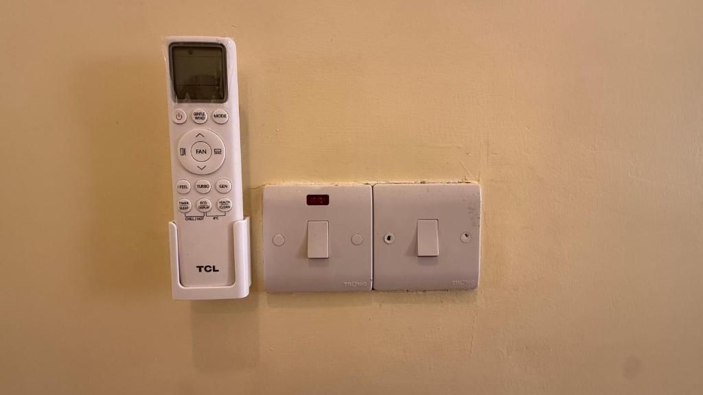 A wall-mounted thermostat and a remote control.