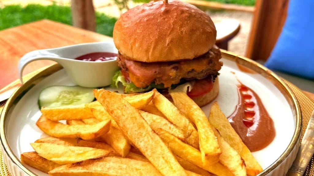 A plate with a burger, fries, and ketchup.