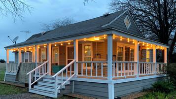 A house with a porch, steps, and string lights.