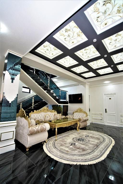 Un interior lujoso con una imponente escalera, muebles elegantes y un techo decorativo.