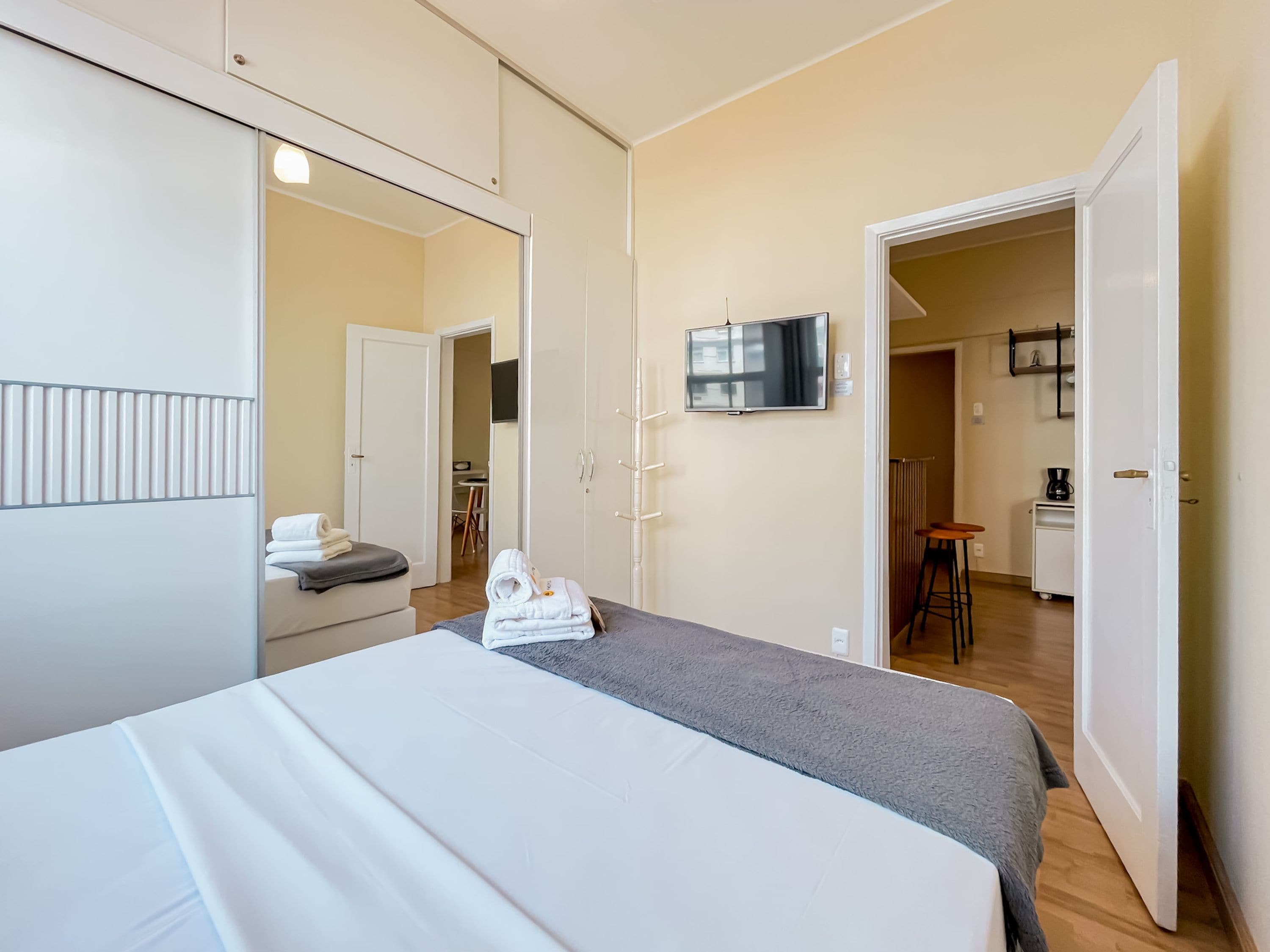 Une chambre d’hôtel équipée d’un lit, d’une télévision, d’une armoire et d’une kitchenette.