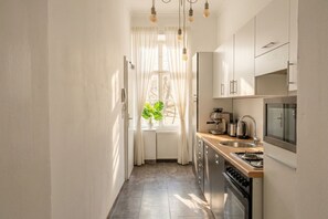 A narrow kitchen with a window, a sink, and a stove. - Bring Everyone 3BR near Belvedere Palace (Vienna)