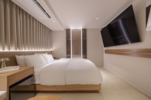 A modern hotel room with a large bed, a bedside table, a desk, a flat-screen TV mounted on the wall, and a window with curtains. - Browndot Hongdae Sinchon (Seoul)