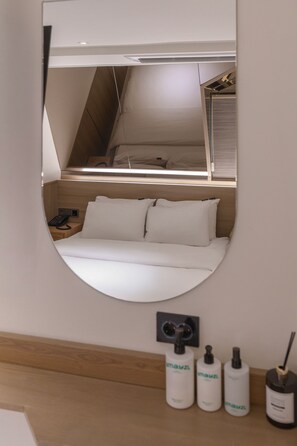 A bedroom with a bed, a bedside telephone, and a mirror on the wall. - Browndot Sinchon (Seoul)