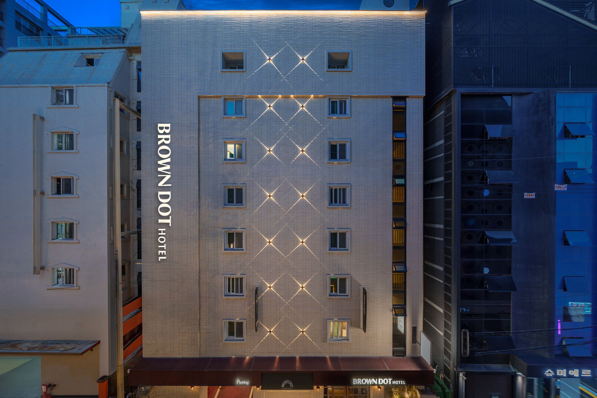 A multi-story hotel with a prominent 'BROWN DOT HOTEL' sign on the facade.