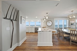 A spacious kitchen with a central island, large windows, and a view of the sea. - 722 Schooner Court at The Sea Pines Resort (Hilton Head Island)