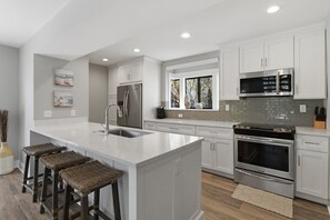 A modern kitchen with a central island, stainless steel appliances, and a view to the outdoors. - 2425 Inland Harbour at The Sea Pines Resort (Hilton Head Island)