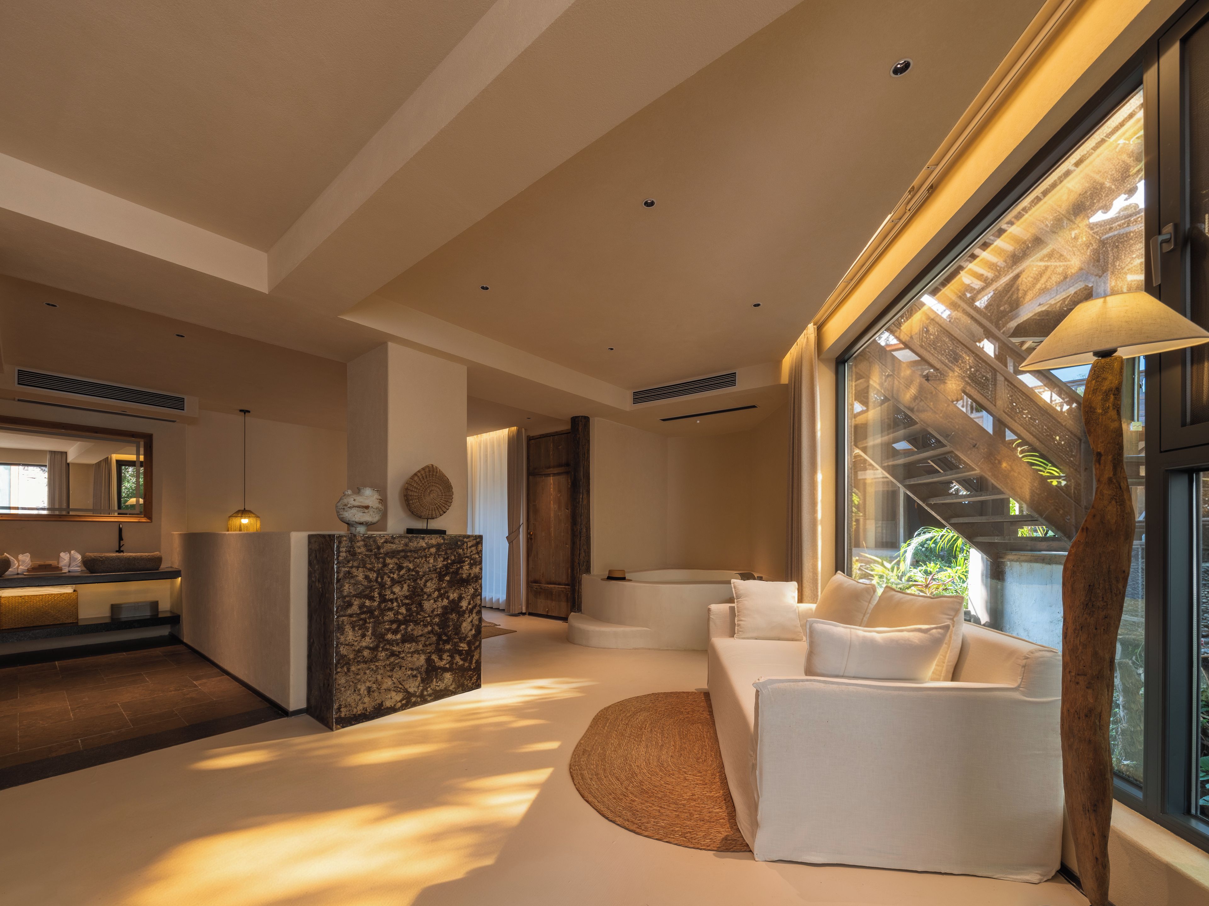 A modern interior with a reception desk, a sofa, and a staircase.