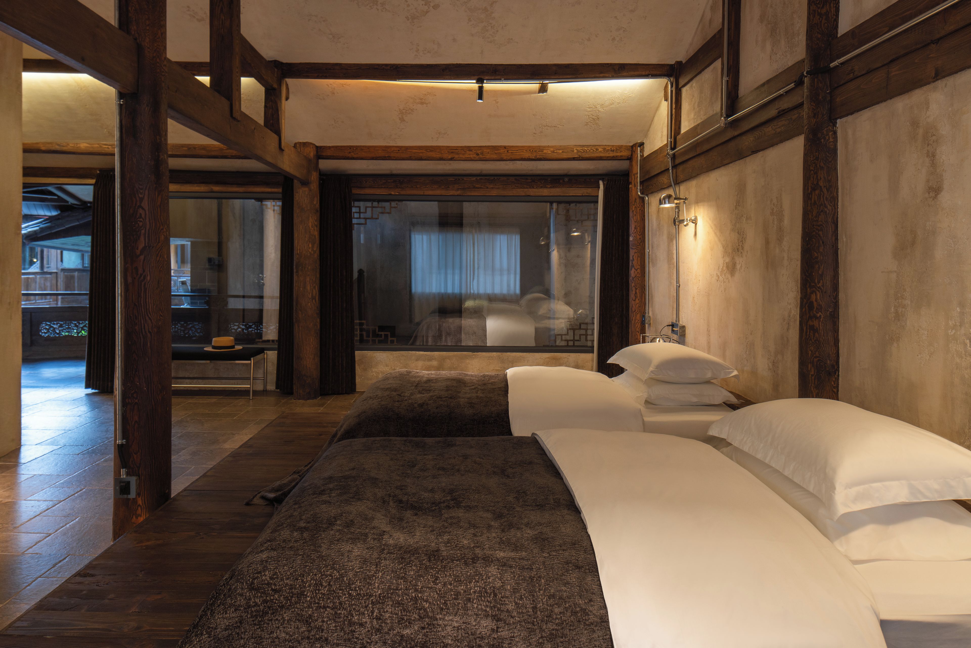 Une chambre avec un grand lit, un plancher en bois et une vue sur un balcon.