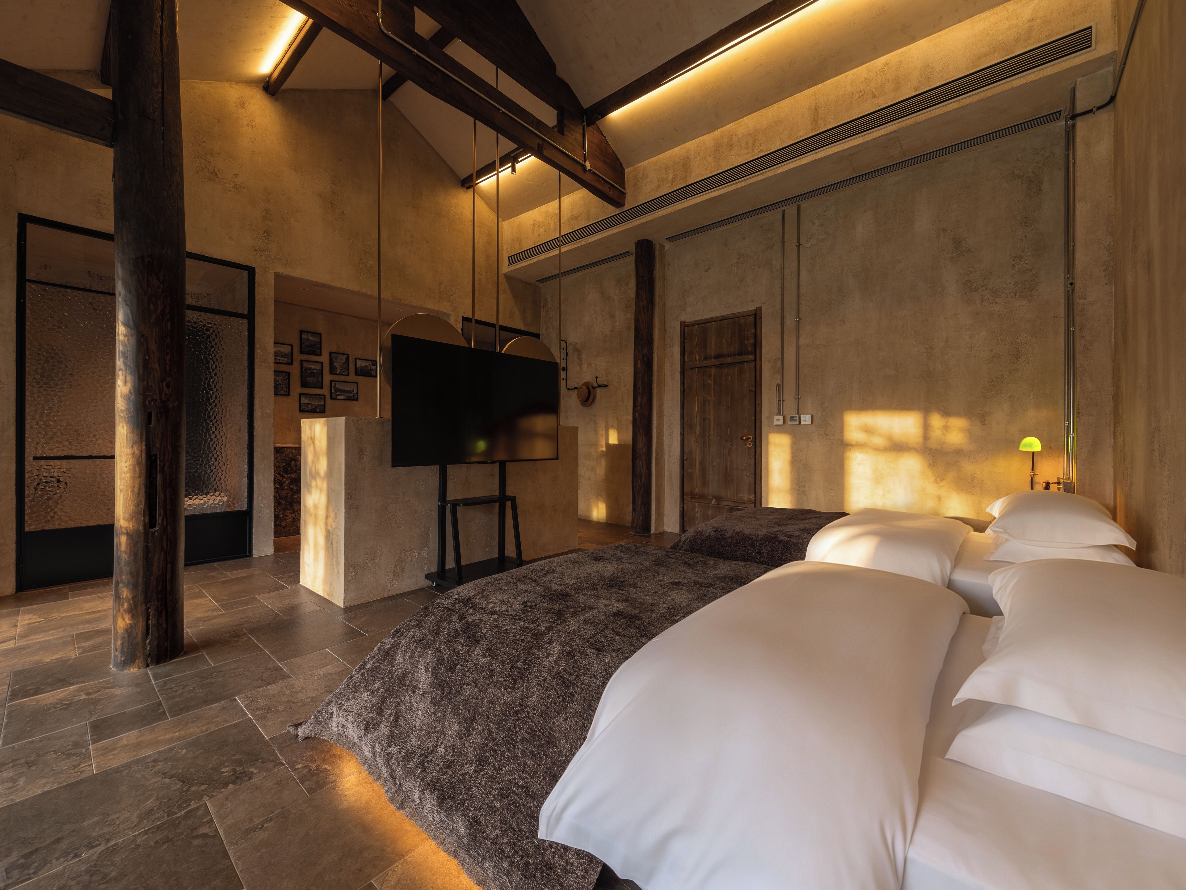 Une chambre dotée d’un grand lit, d’un téléviseur à écran plat et d’une structure de plafond en bois.