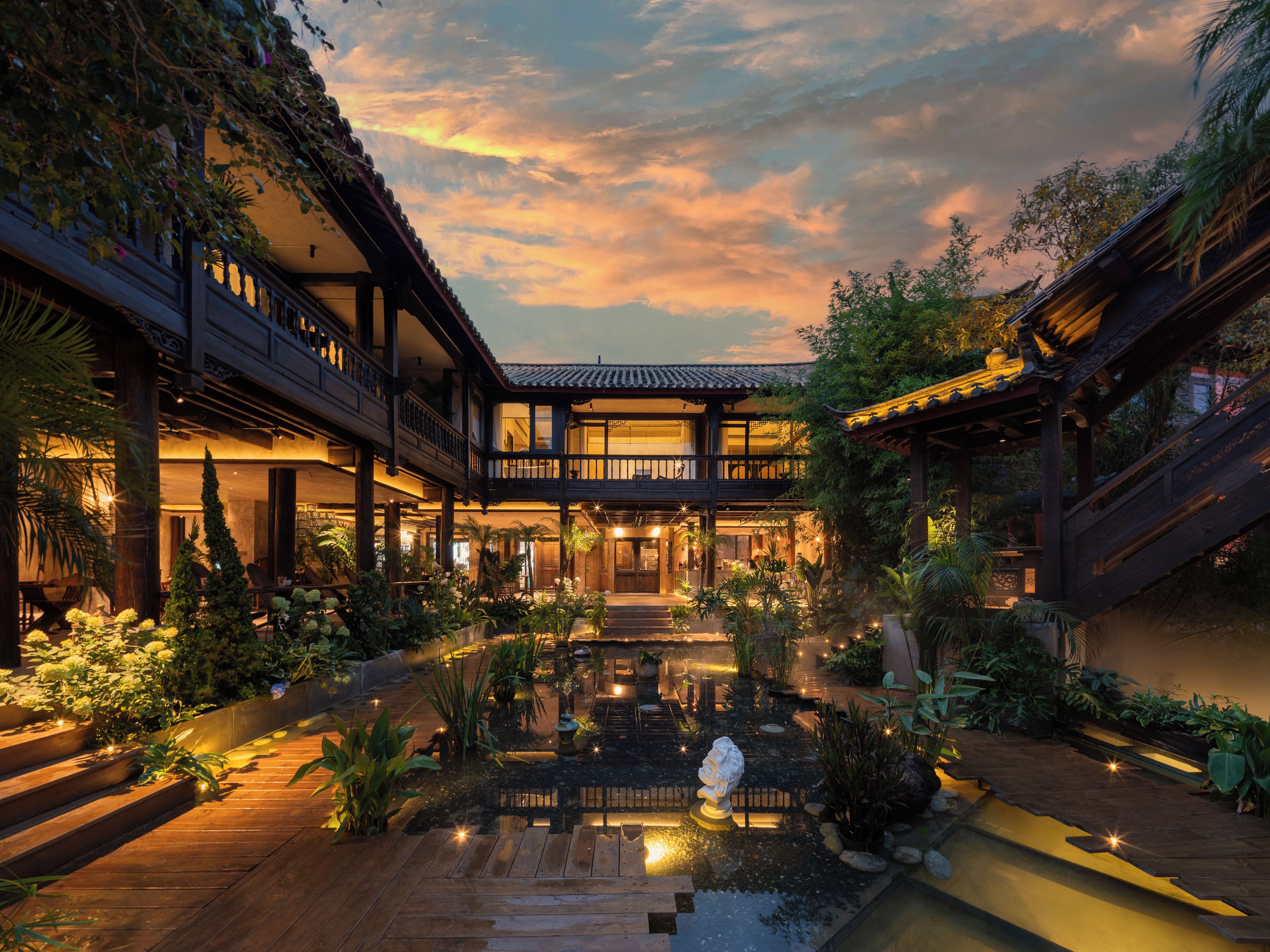 A traditional building with a courtyard, wooden deck, and a water feature.
