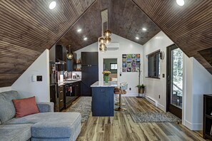 A modern loft with a kitchen, dining area, and living space. - Haven Haus Properties (Eagle River)