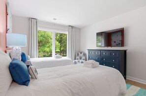A bedroom with two beds, a dresser, a lamp, and a painting on the wall. - 212 Twin Oaks at The Sea Pines Resort (Hilton Head Island)