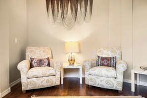 A room with two armchairs, a side table with a lamp, and a patterned wall hanging. - YOUR ARIZONA HOME FOR THE MONTH! (Goodyear)