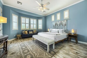 A bedroom with a bed, a sofa, a bench, a ceiling fan, and a patterned rug. - YOUR ARIZONA HOME FOR THE MONTH! (Goodyear)