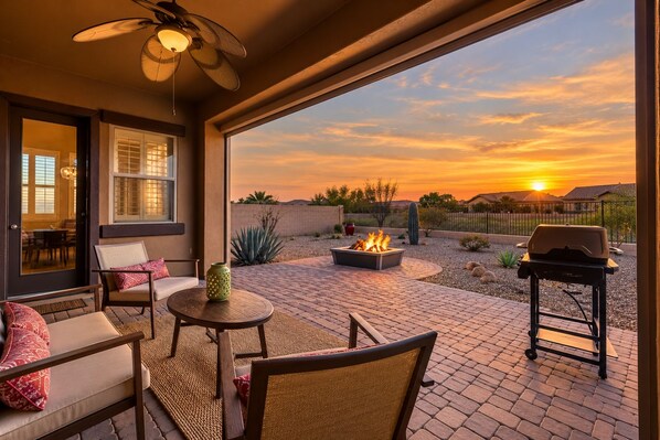An outdoor patio with a fire pit, seating, and a view of the sunset. - YOUR ARIZONA HOME FOR THE MONTH! (Goodyear)
