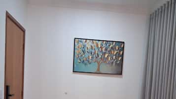 Un comedor con una mesa y sillas, un cuadro en la pared y una puerta.