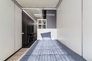 A narrow room with a bed, a desk, and a chair. - 54 - Le Lokup - Wifi - Proche tram (Reims)