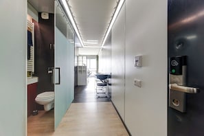 Ein moderner Flur mit Toilette, Waschbecken und einer Tür mit Zahlenschloss.