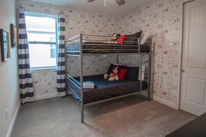 A bunk bed room with a window, curtains, and a door. - 6BR Near Disney Pool, spa & 2 Game Rooms (Kissimmee)