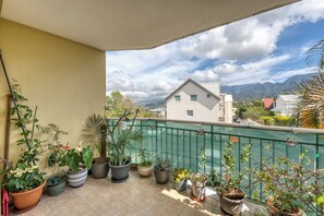 Ein Balkon mit Blumentöpfen und Blick auf Berge.