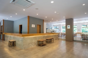 A modern interior with a reception desk, seating area, and large windows. - OKU-AMAGASE ONSEN OHANA (Hita)