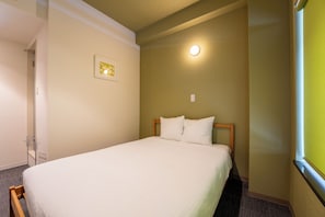 A single bed with a wooden headboard in a room with a plain wall and a light fixture. - OKU-AMAGASE ONSEN OHANA (Hita)