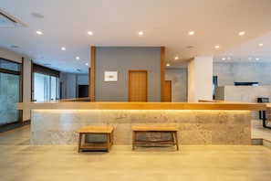 A reception desk with a marble counter, wooden stools, and a framed picture on the wall. - OKU-AMAGASE ONSEN OHANA (Hita)