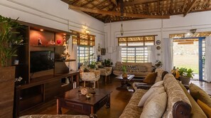 Ein gemütliches Wohnzimmer mit Fernseher, Sofas und einem Couchtisch.