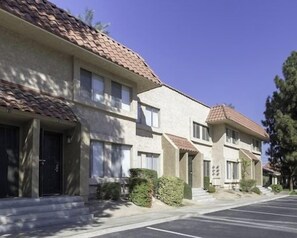 A row of two-story buildings with a uniform architectural style, featuring a tiled roof and a consistent facade. - Walk-to-Head-Trip Indio Retreat (Indio)