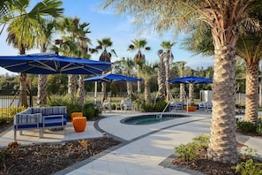 A poolside area with lounge chairs, umbrellas, and palm trees. - 7BR Near Disney Private Pool, spa & Game Room (Kissimmee)
