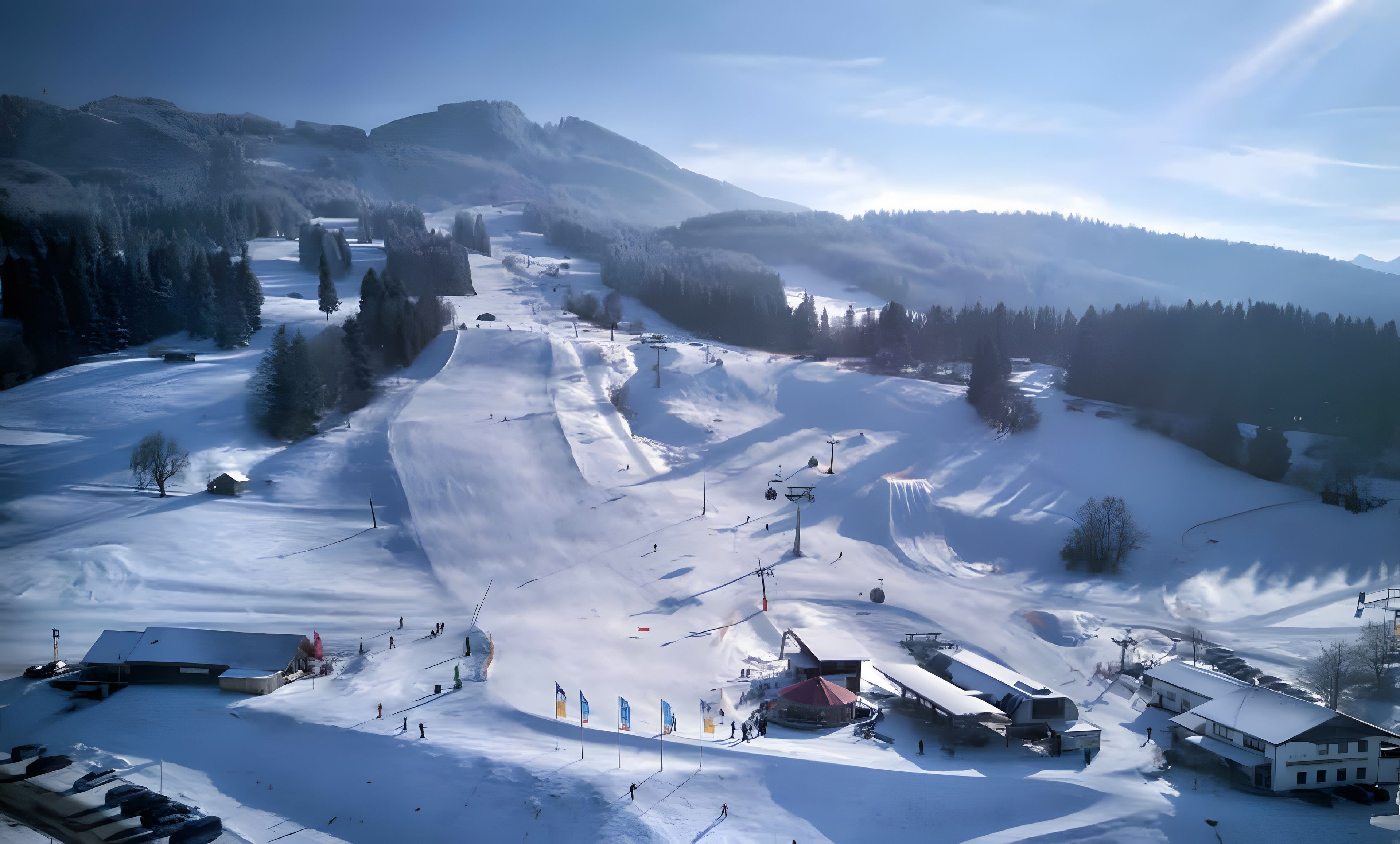 Une station de ski enneigée, dotée de remontées mécaniques, de pistes et de bâtiments.