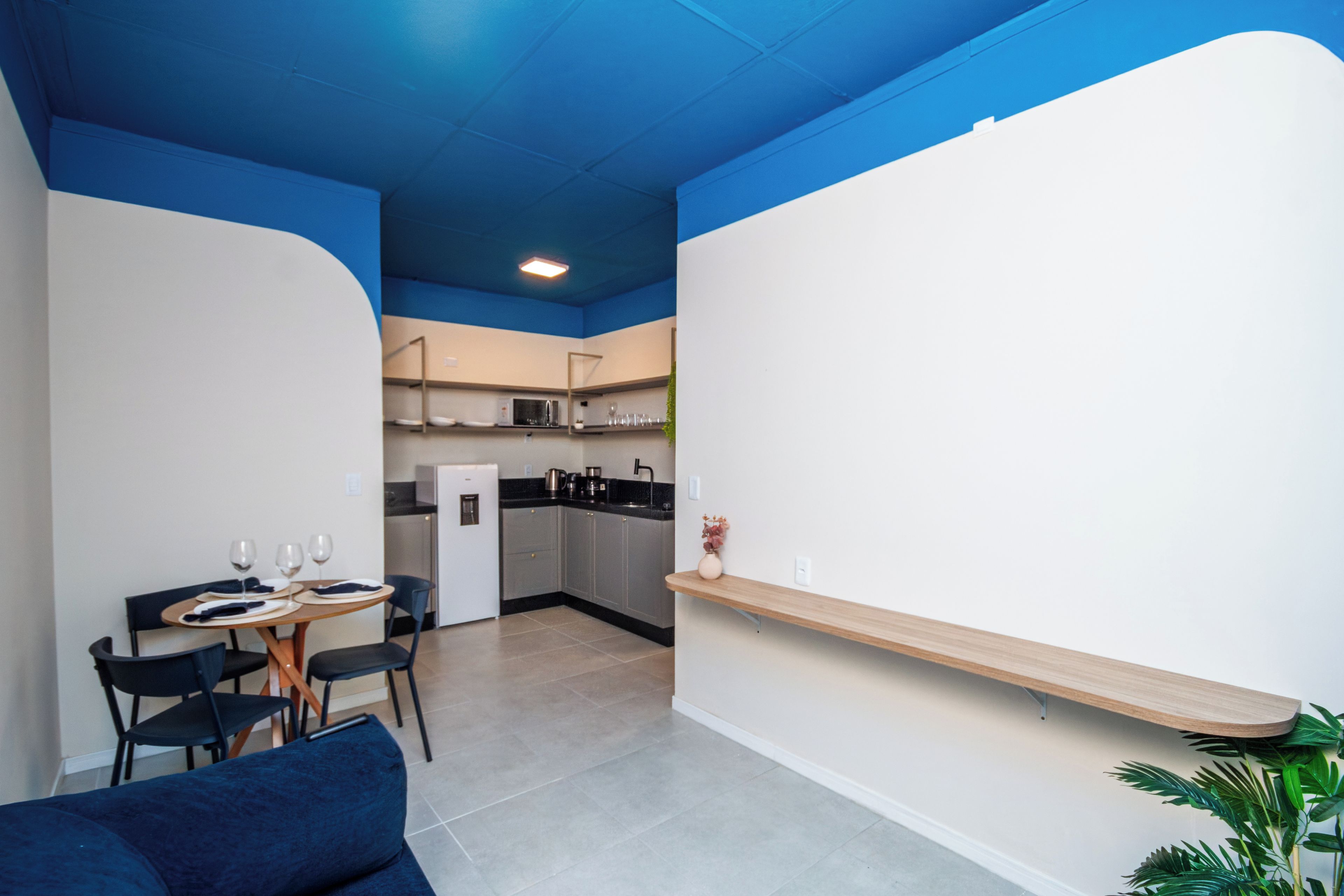 A modern kitchen with a dining area, a refrigerator, and a coffee machine.