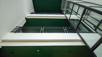 A multi-level interior with glass railings and a green and white color scheme.
