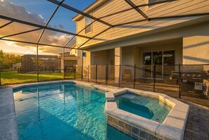 A swimming pool with a hot tub, a covered patio, and a barbecue area. - Solterra Serenity 7BR Luxury Estate w Private Pool (Davenport)